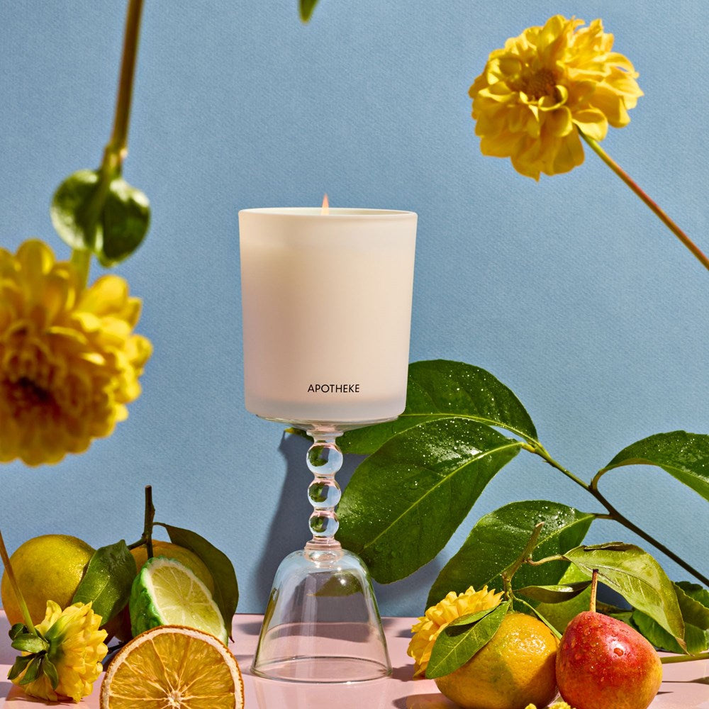 APOTHEKE Bergamot Tangerine candle with citrus fruit and yellow flowers