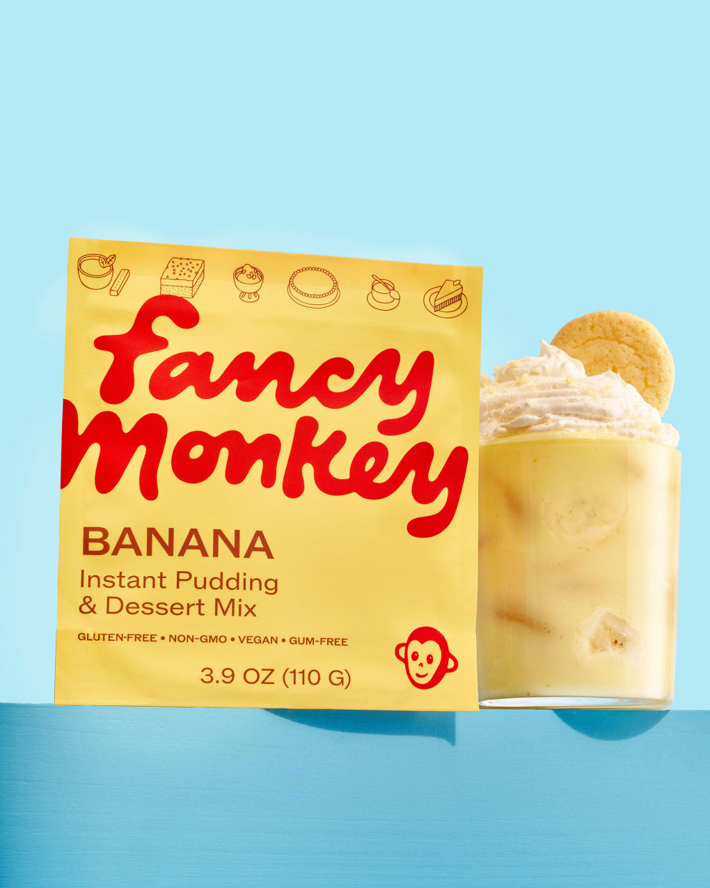 Fancy Monkey Banana Instant Pudding & Dessert Mix pouch beside banana pudding on a blue background