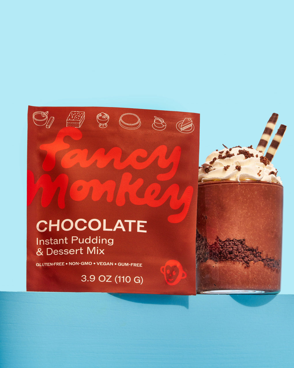Fancy Monkey Chocolate Instant Pudding & Dessert Mix pouch beside chocolate pudding with whipped topping