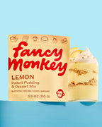 Fancy Monkey Lemon Instant Pudding & Dessert Mix pouch beside a layered lemon dessert on a blue background