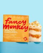 Fancy Monkey Salted Caramel Instant Pudding & Dessert Mix pouch beside a caramel dessert on a blue background